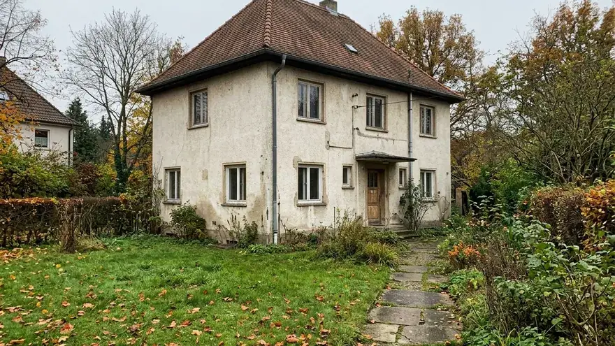 Eigentümerin fotografiert mit dem Handy einen dunklen Fleck an der Wohnzimmerwand